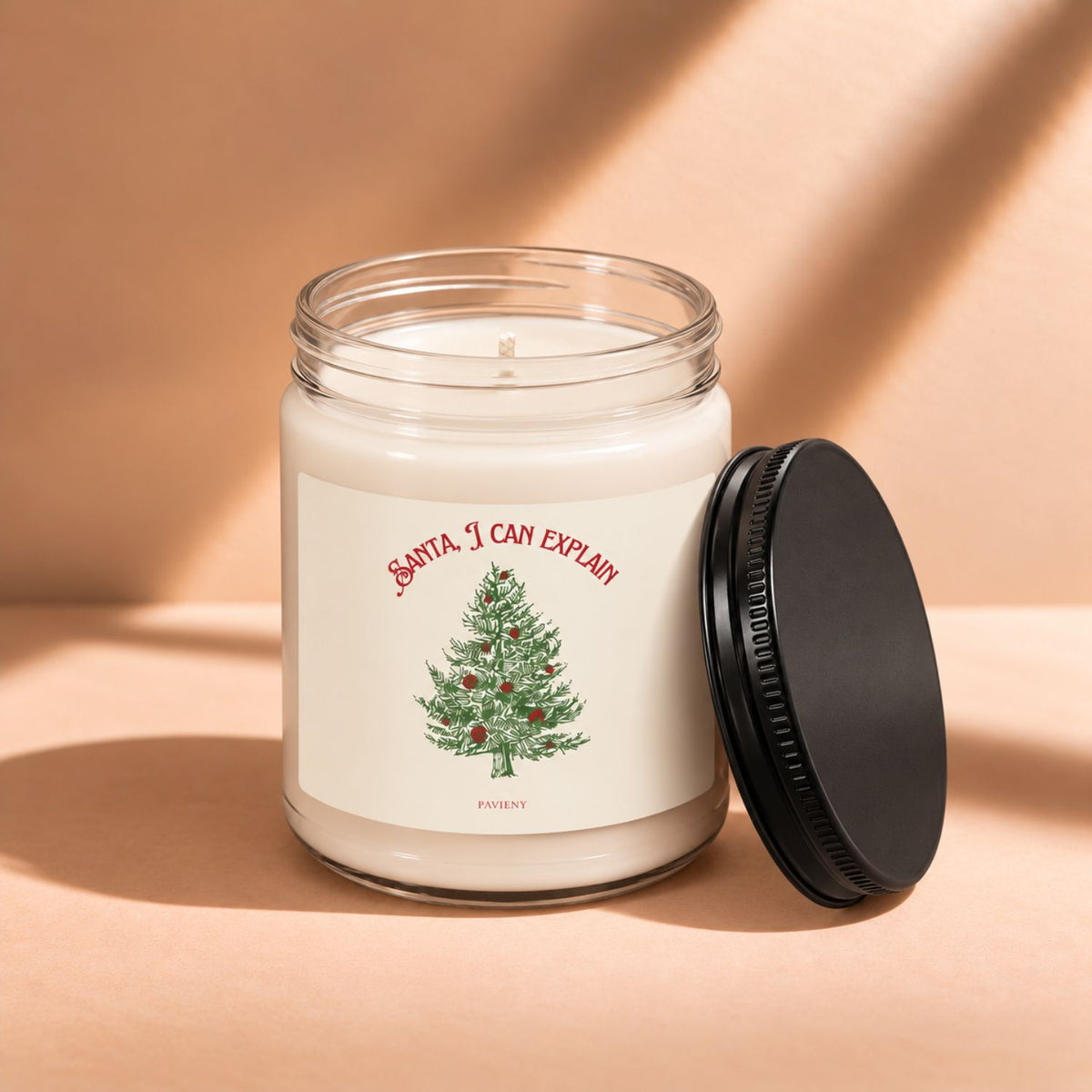 Open 9oz Santa I Can Explain candle with the black lid beside the clear glass jar.