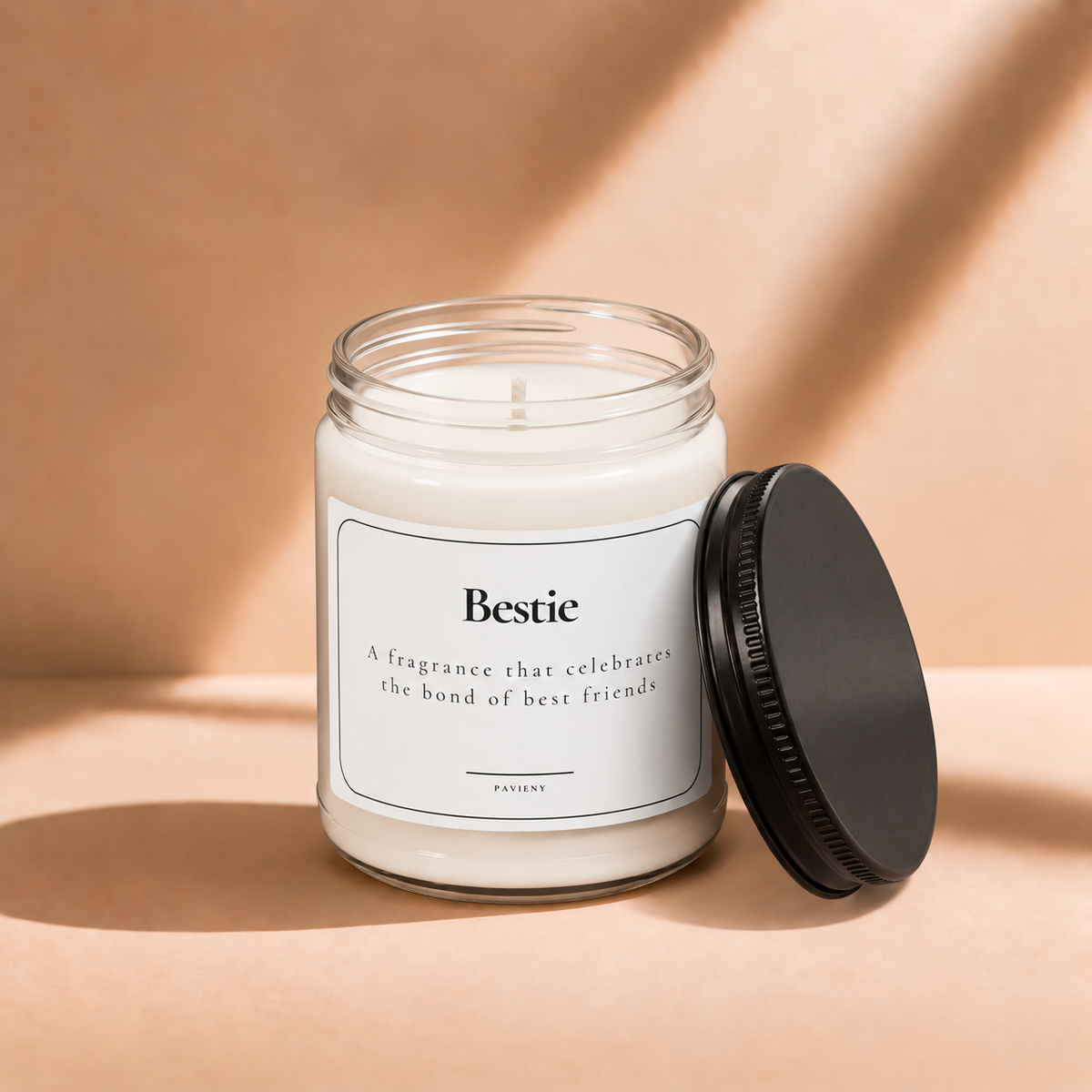 Open 9oz Bestie scented soy candle with the black lid beside the clear glass jar.