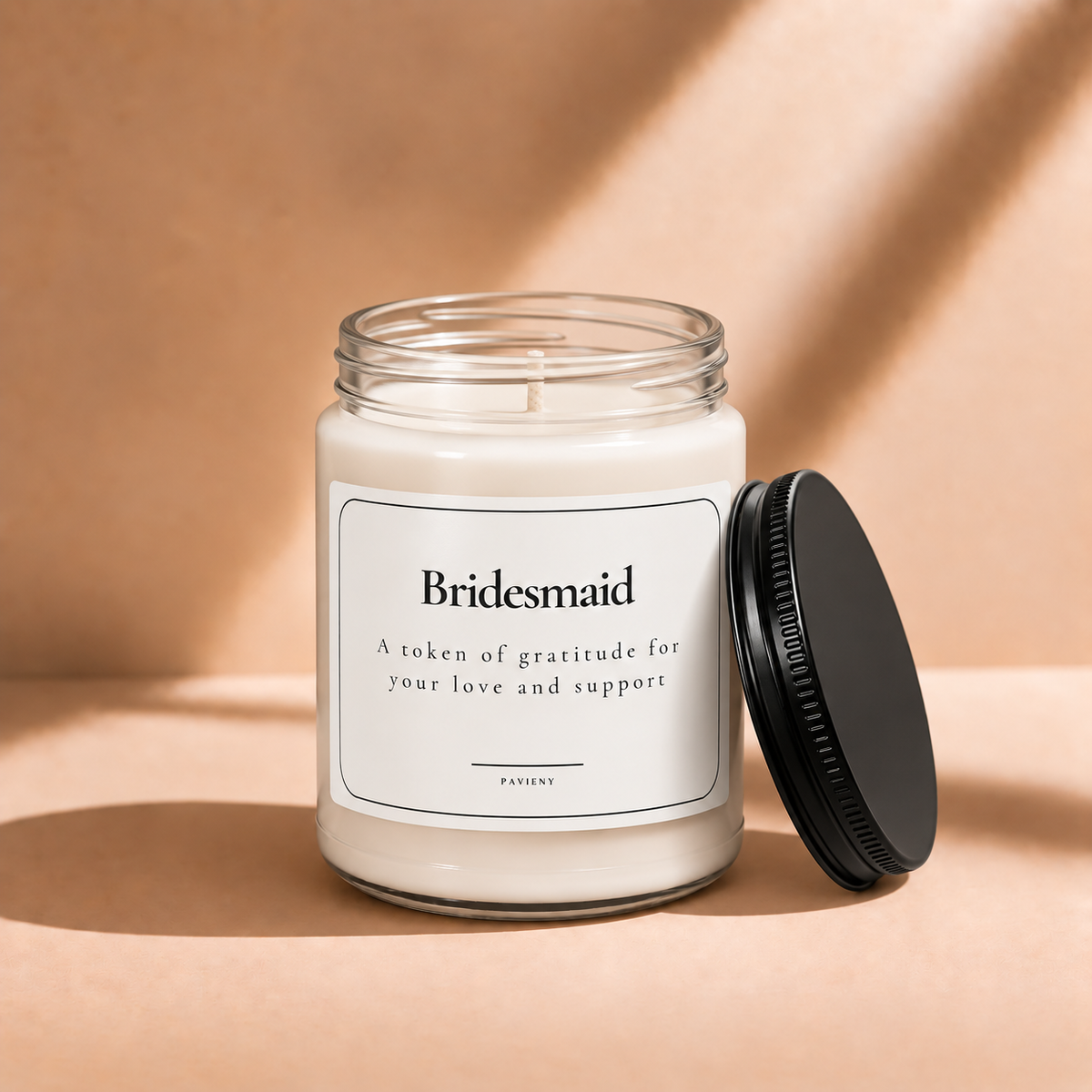 Open 9oz Bridesmaid scented soy candle with the black lid beside the clear glass jar.