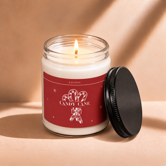 Lit 9oz Candy Cane scented soy candle with a warm flame, a festive Christmas gift for the holiday season.