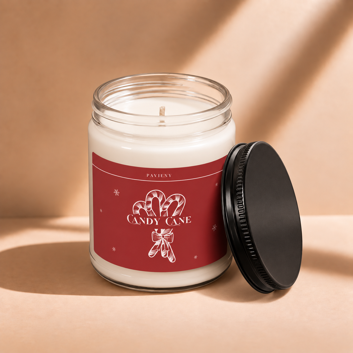 Open 9oz Candy Cane scented soy candle with the black lid beside the clear glass jar.