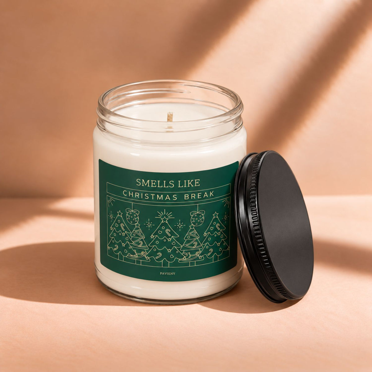 Open 9oz Christmas Break scented soy candle with the black lid beside the clear glass jar.
