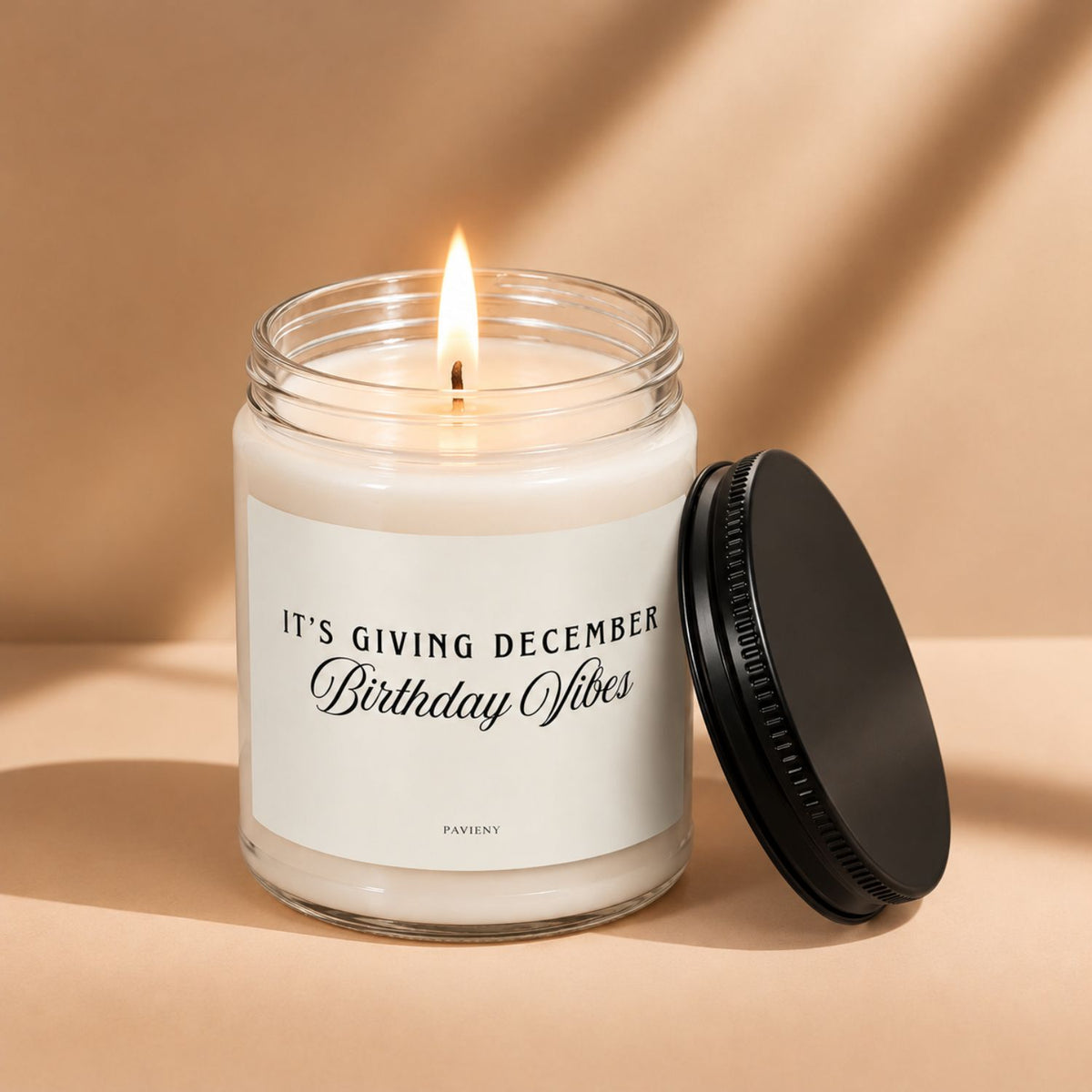 Lit December birthday scented candle in a glass jar, a thoughtful birthday gift for someone celebrating in December.