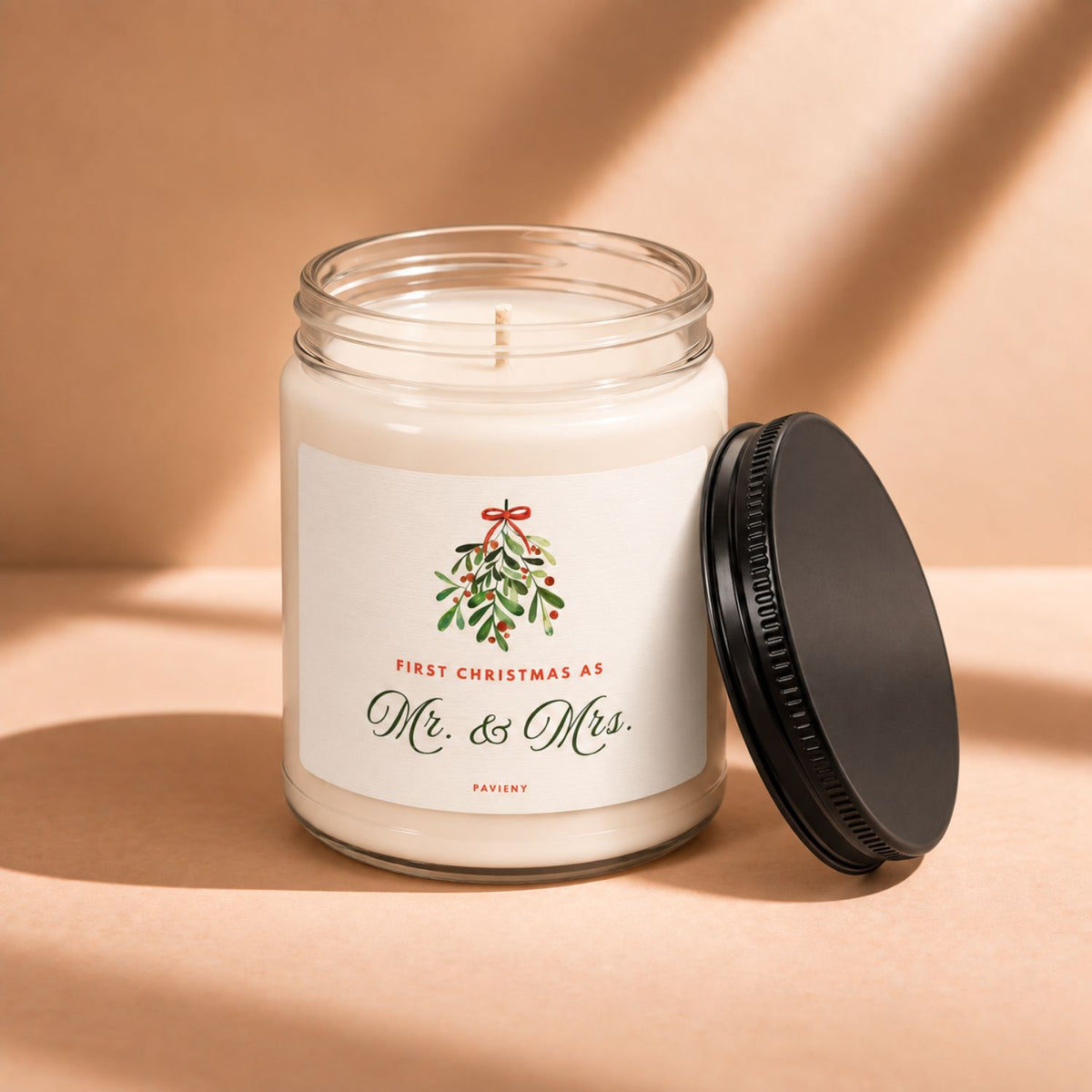 Open 9oz First Christmas scented candle with the black lid beside the glass jar.