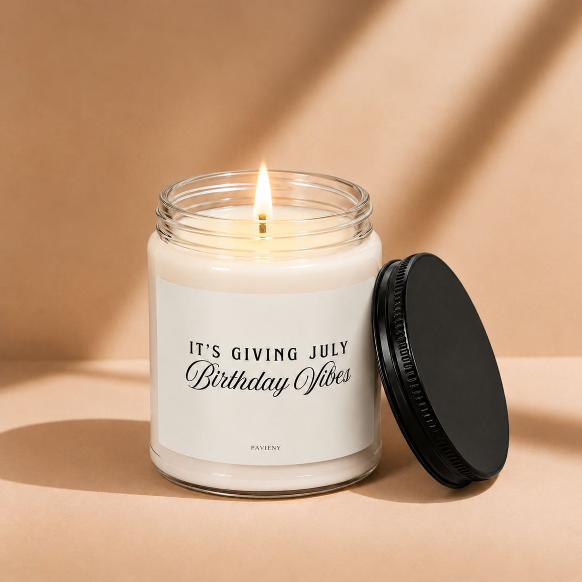 Lit July birthday scented candle in a glass jar, a thoughtful birthday gift for someone born in July.