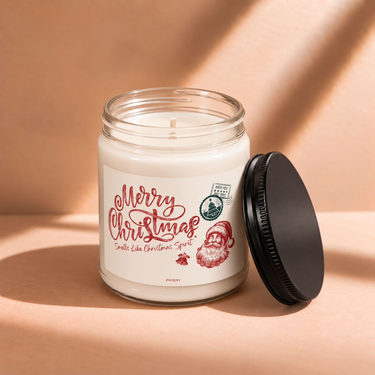 Open 9oz Merry Christmas scented soy candle with the black lid beside the clear glass jar.