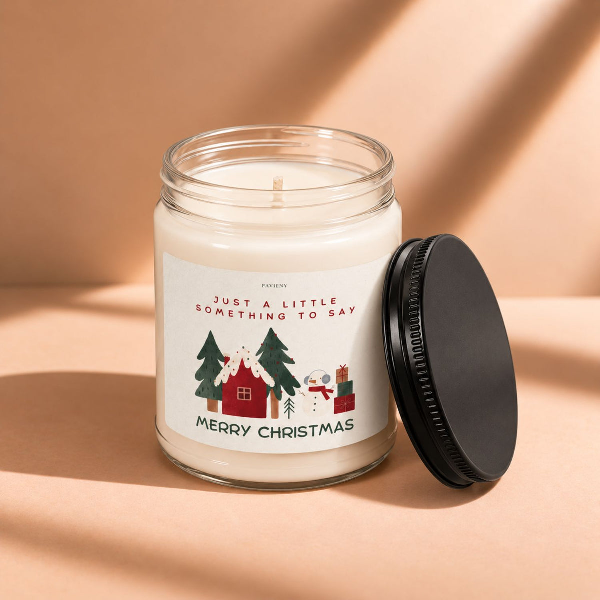 Open 9oz Merry Christmas scented candle with the black lid beside the glass jar