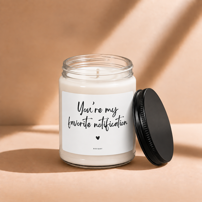 Open 9oz My Favorite Notification scented soy candle with the black lid beside the clear glass jar.