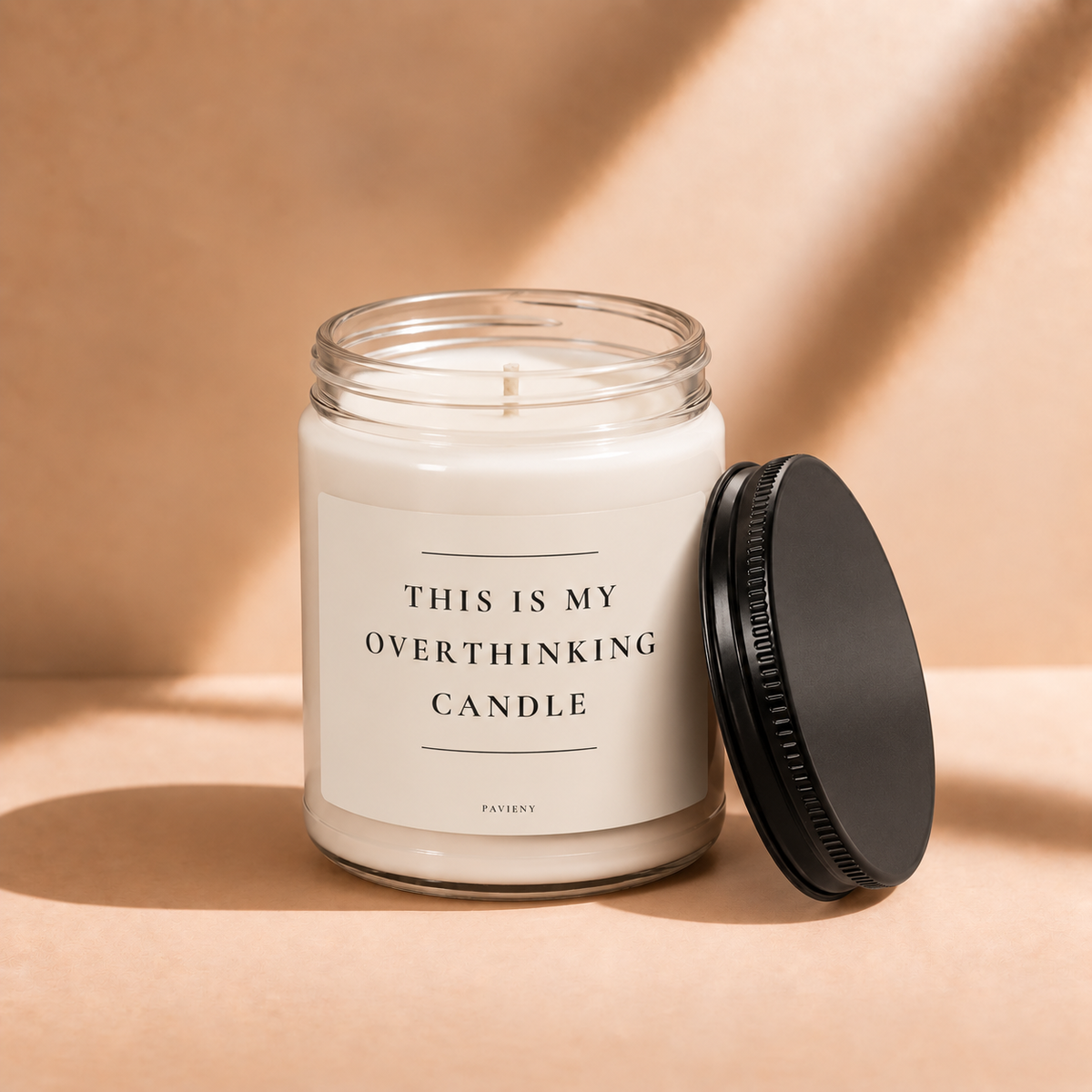 Open 9oz Overthinking scented soy candle with the black lid beside the clear glass jar.