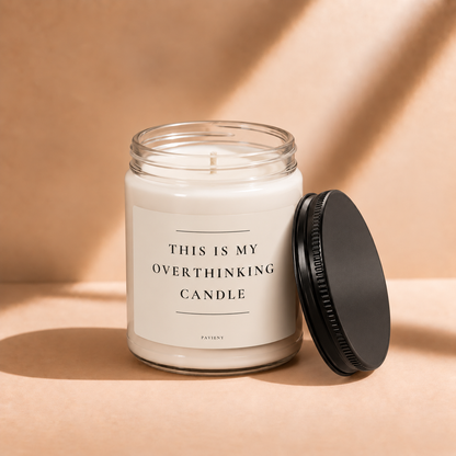 Open 9oz Overthinking scented soy candle with the black lid beside the clear glass jar.