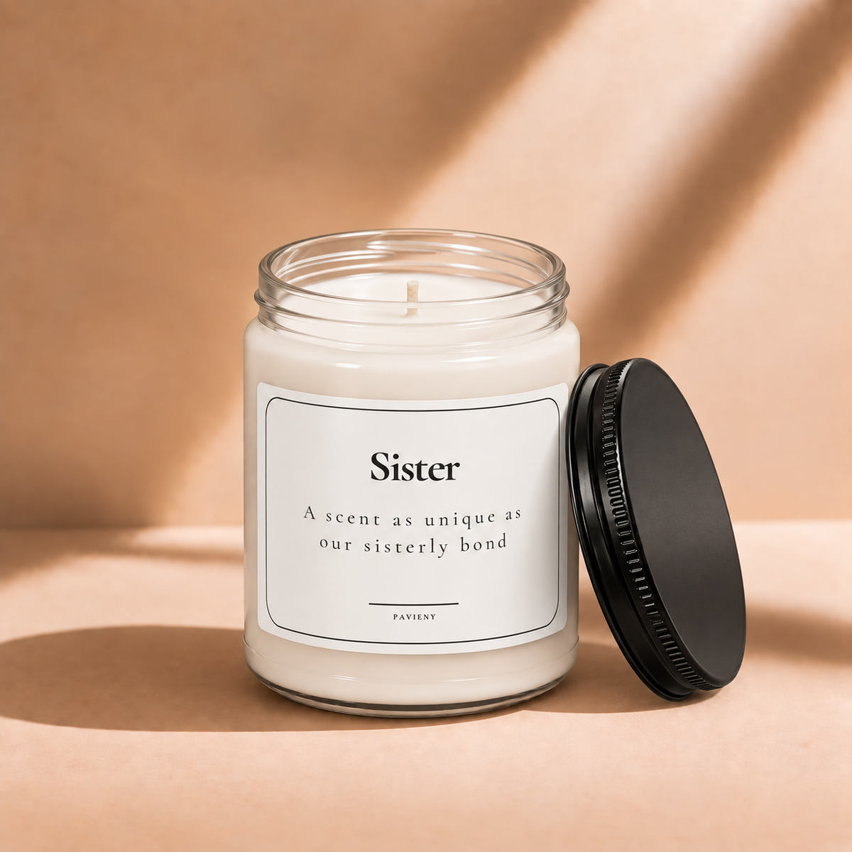 Open 9oz Sister scented soy candle with the black lid beside the clear glass jar.