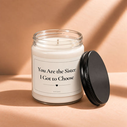 Open 9oz Sister I Got to Choose candle with the black lid beside the clear glass jar.
