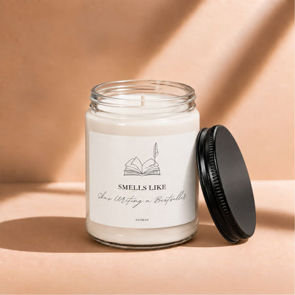 Open 9oz Writing a Bestseller candle with the black lid beside the glass jar.